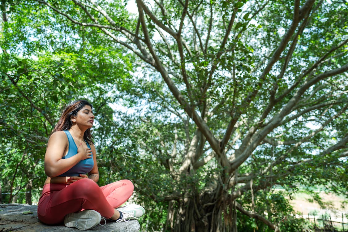 Donna in atteggiamento sereno all'aperto tra alberi | benessere psicologico dopo il primo colloquio