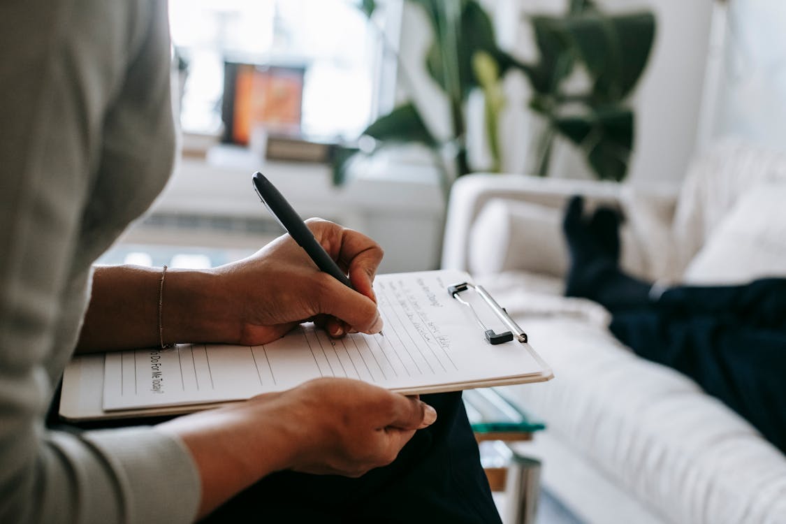 Terapeuta con appunti in setting professionale caldo durante un colloquio | come uscire da una relazione tossica
