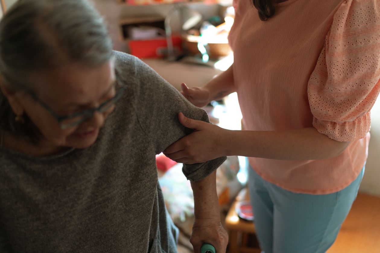 Caregiver che sostiene una persona anziana in casa