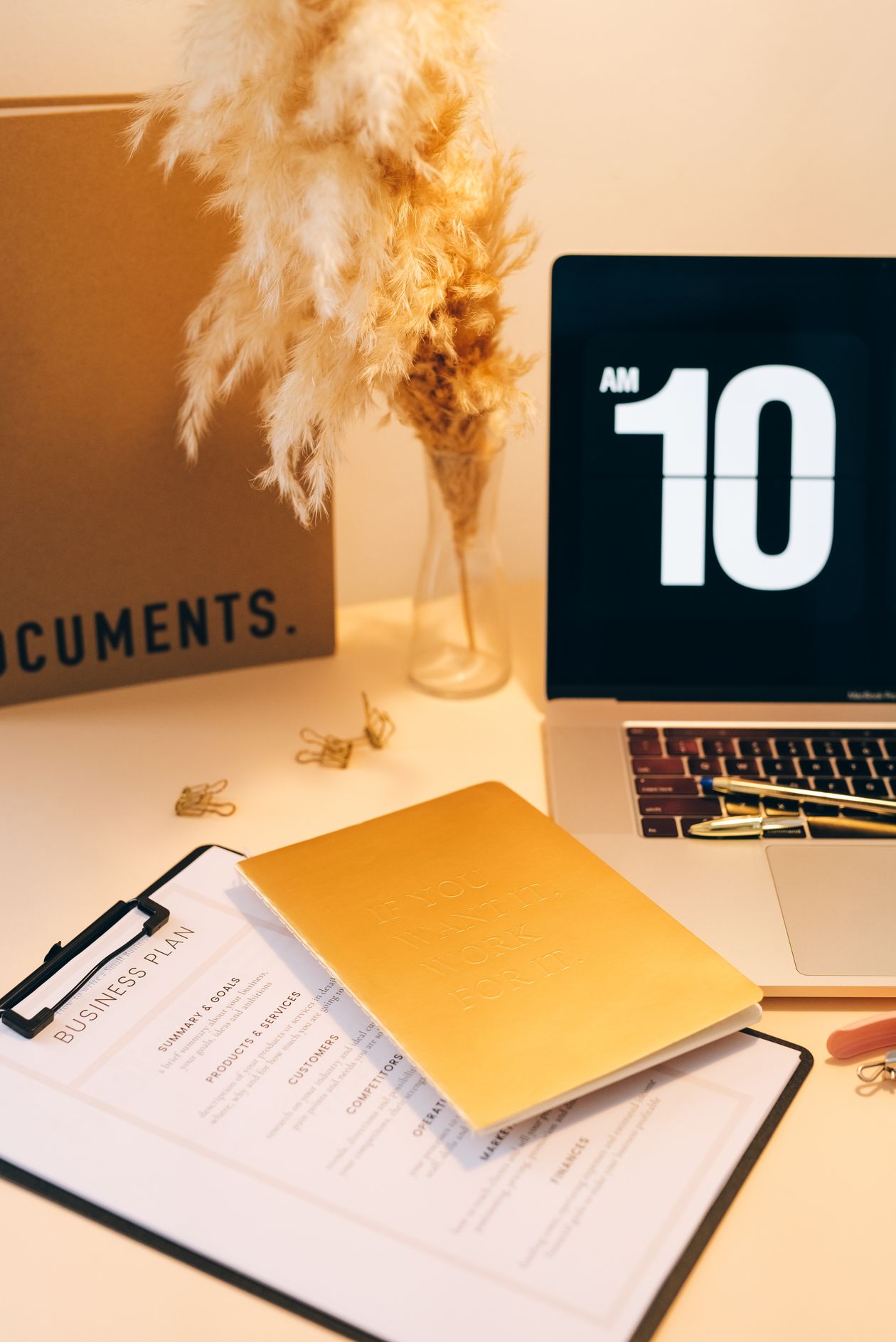 Scrivania con computer, documenti e orologio per rappresentare il rapporto con il tempo